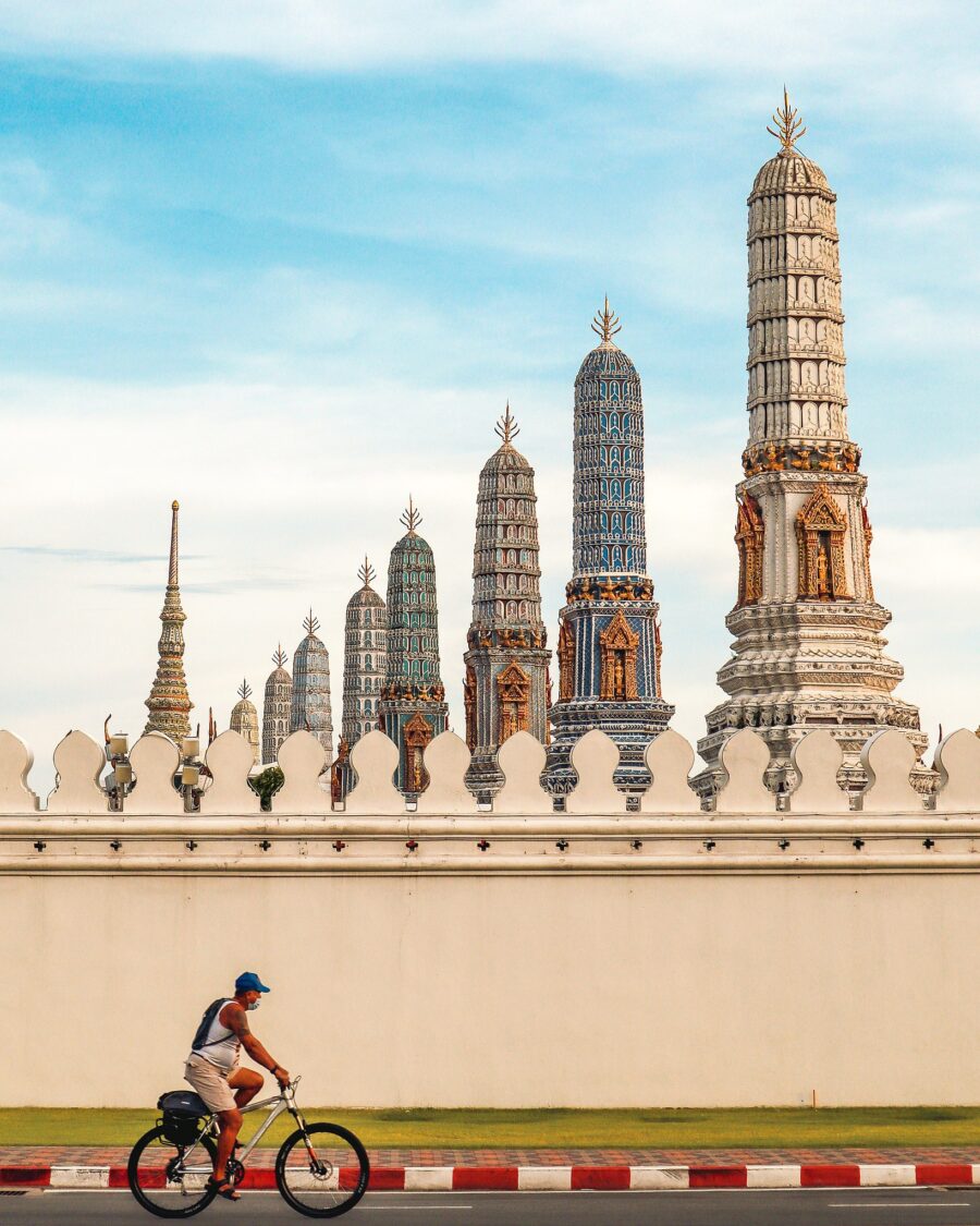 A man cycling outside the wall of the Grand Palace