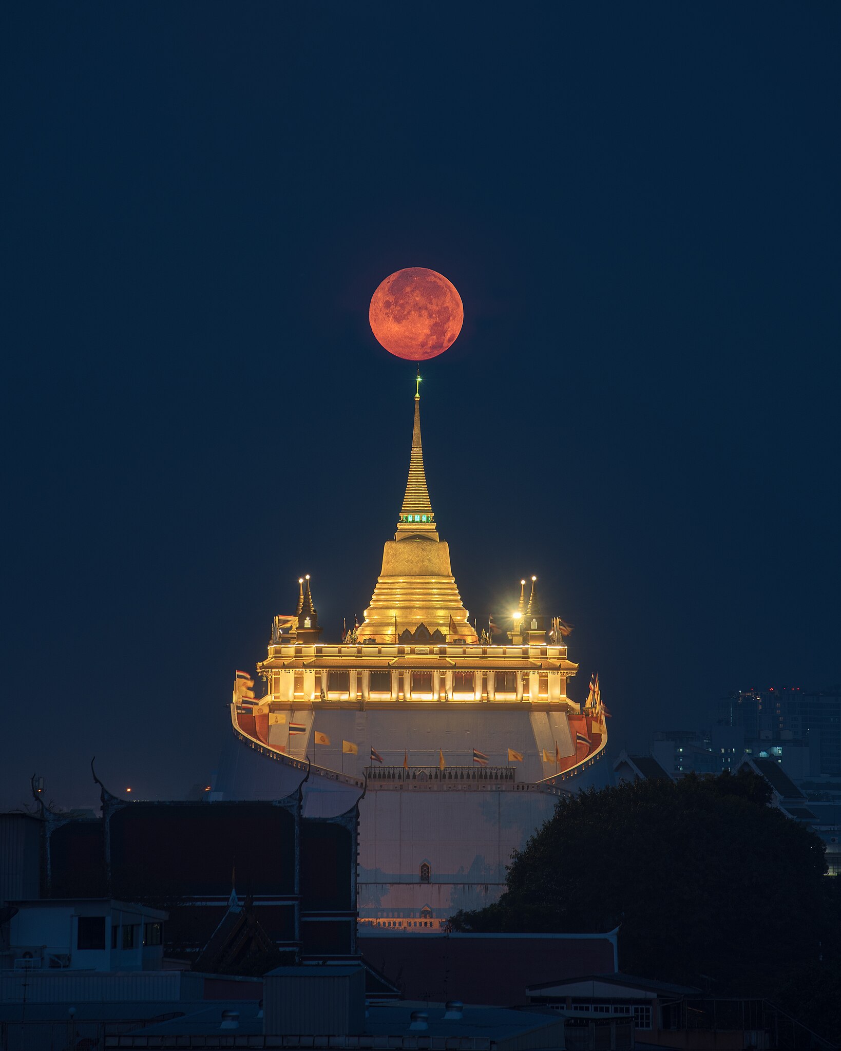 Wat Saket in Bangkok, Thailand, with the full moon in the background